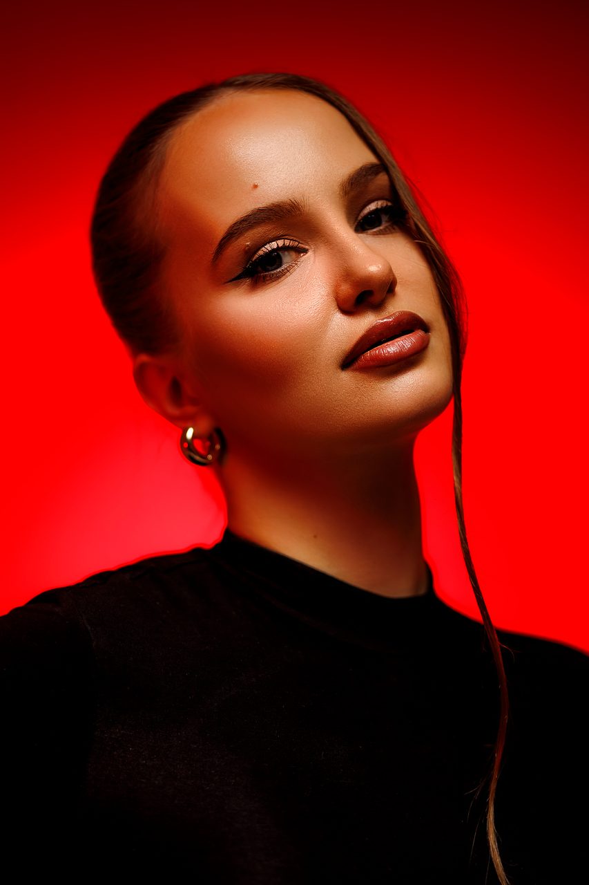 Beauty portrait with glamour makeup on a red backdrop — studio photography in Budapest