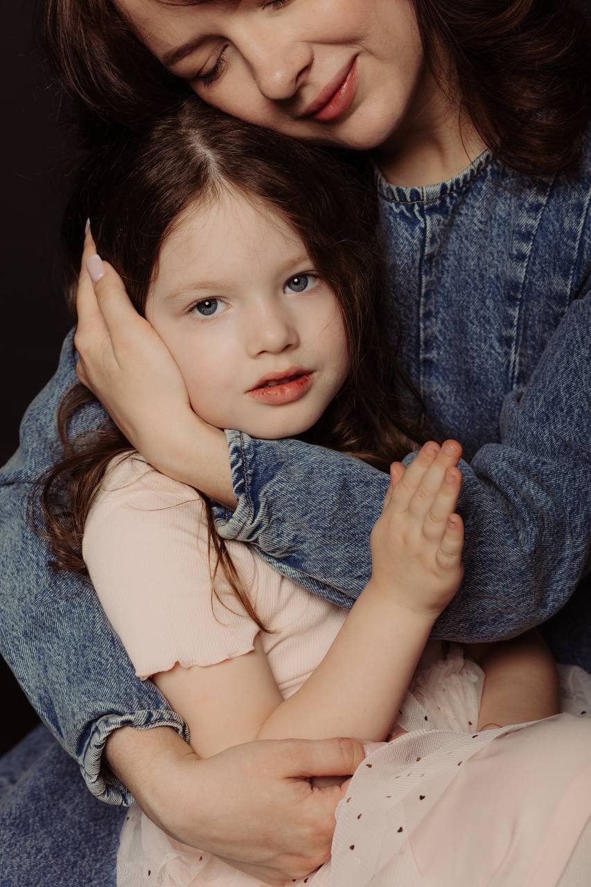 Emotional studio portrait of a mother holding her daughter — family photographer in Budapest