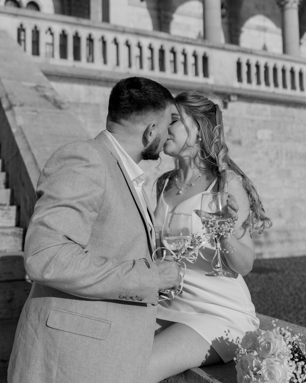 Couple kissing with champagne at Fisherman's Bastion in Budapest — black-and-white wedding photo