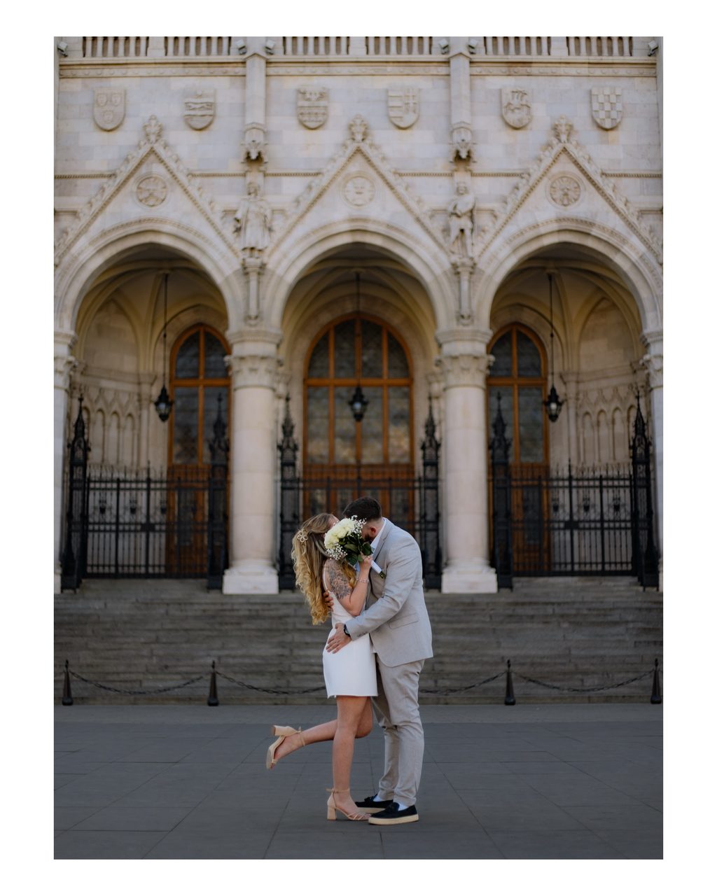 Wedding couple kissing under the arches of the Hungarian Parliament in Budapest